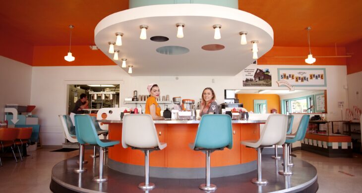 inside shake shake shake, blue and white chairs around a round bar while servers make shakes and tacoma's favorite burgers