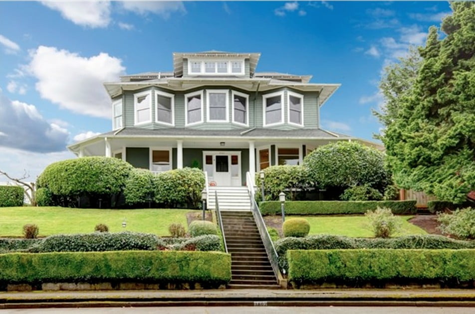 a large home on a hill above a sidewalk in old town tacoma