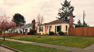 Yellow house with green shutters and an american flag in central tacoma WA
