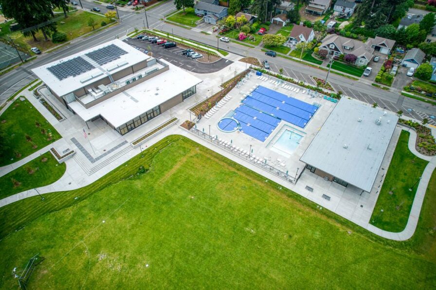 a photo of the city of fircrest pool from above with a green lawn beyond