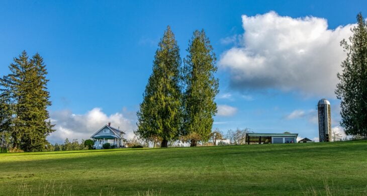 a photo of a home on land beyond gig harbor with trees and a blue sky