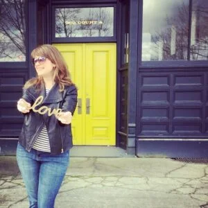 rochelle bergstrom holding a sign that says love