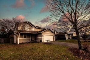 a beige home with a driveway and 2 car garage in a housing development in Frederickson WA