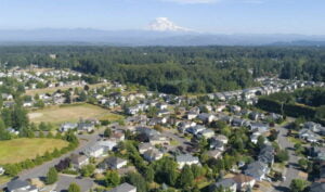 Homes in south hills sunrise neighborhood photographed from the air with mt rainier in the background on a sunny day