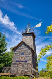 an old wooden windmill in edgewood washington with blue skies and trees behind