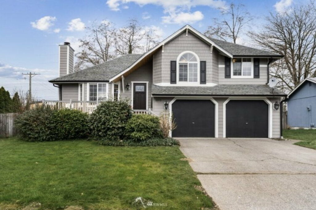 a gray 2 story house with black garage doors and black shutters in browns point tacoma