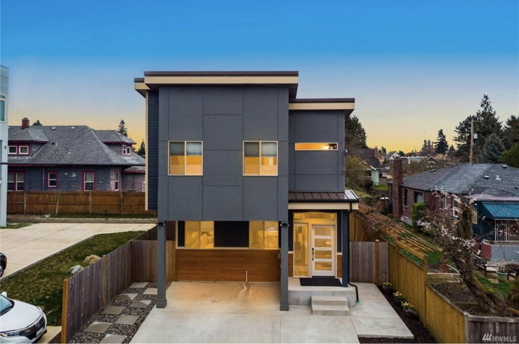 a blueish grey modern house with steps leading up to the door and a driveway in central tacoma washington