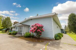 a photo of the waller road grange with a pink rhodie in front