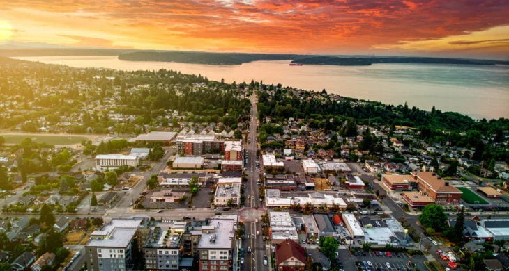 A photo of a sunset over the North Tacoma Neighborhood of Proctor in Tacoma with Commencement Bay in the distance and homes and apartments in the forefront.