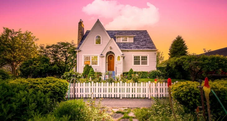 A home in Tacoma's lincoln district with a white picket fence and red door