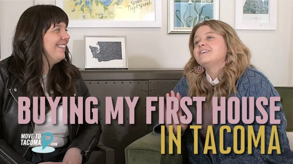 A photo of two people Marguerite and Keryn, sitting on a couch. Marguerite has long dark hair keryn has long blond hair. The words "Buying My First House in Tacoma" are written across the photo.