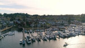 A view of Gig Harbor at sunset from above the habor looking out over boats lines up at the dock showing what it's like living in gig harbor.