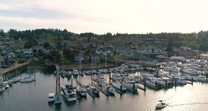 A view of Gig Harbor at sunset from above the habor looking out over boats lines up at the dock showing what it's like living in gig harbor.