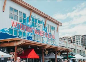 A Sign painted in Red and Blue on the side of a building in Tacoma's Point Ruston reads "Waterfront Market at Ruston"