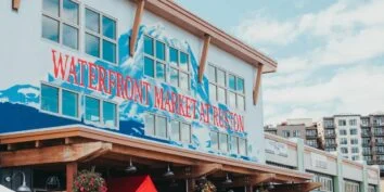 A Sign painted in Red and Blue on the side of a building in Tacoma's Point Ruston reads 