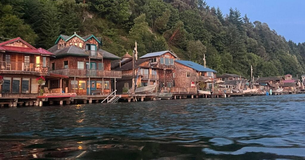 The waterfront neighborhood of Salmon Beach in Tacoma Washington photographed from the water. A row of cedar shake homes built on piers right on the Puget Sound in the North Tacoma area.