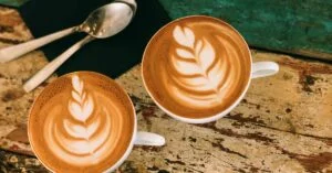 a photo of two coffee cups with latte foam art on a granite counter in Tacoma washington