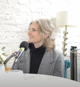 Catherine Feeney Tacoma Artist and founder of South Sound Plein Air sits at the podcast mic in a black shirt and grey blazer.