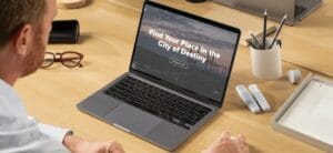 A man looks at a laptop with the homepage of MovetoTacoma.com on it with the words "Find Your Place in the City of Destiny"