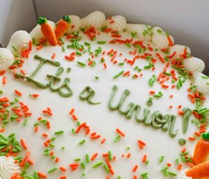 A white cake with sprinkles has "It's a Union!" written in Green Frosting.