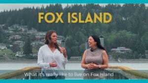 Two people (Marguerite an Kris) walk along a dock at a home on Fox Island near Tacoma Washington with the puget sound in the background.